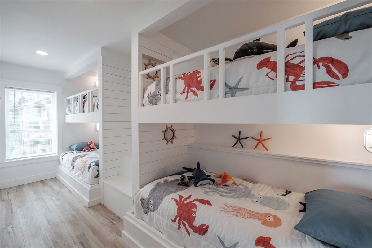 Stylish built-in bunks with coastal decor create a playful, inviting space that kids will love. 