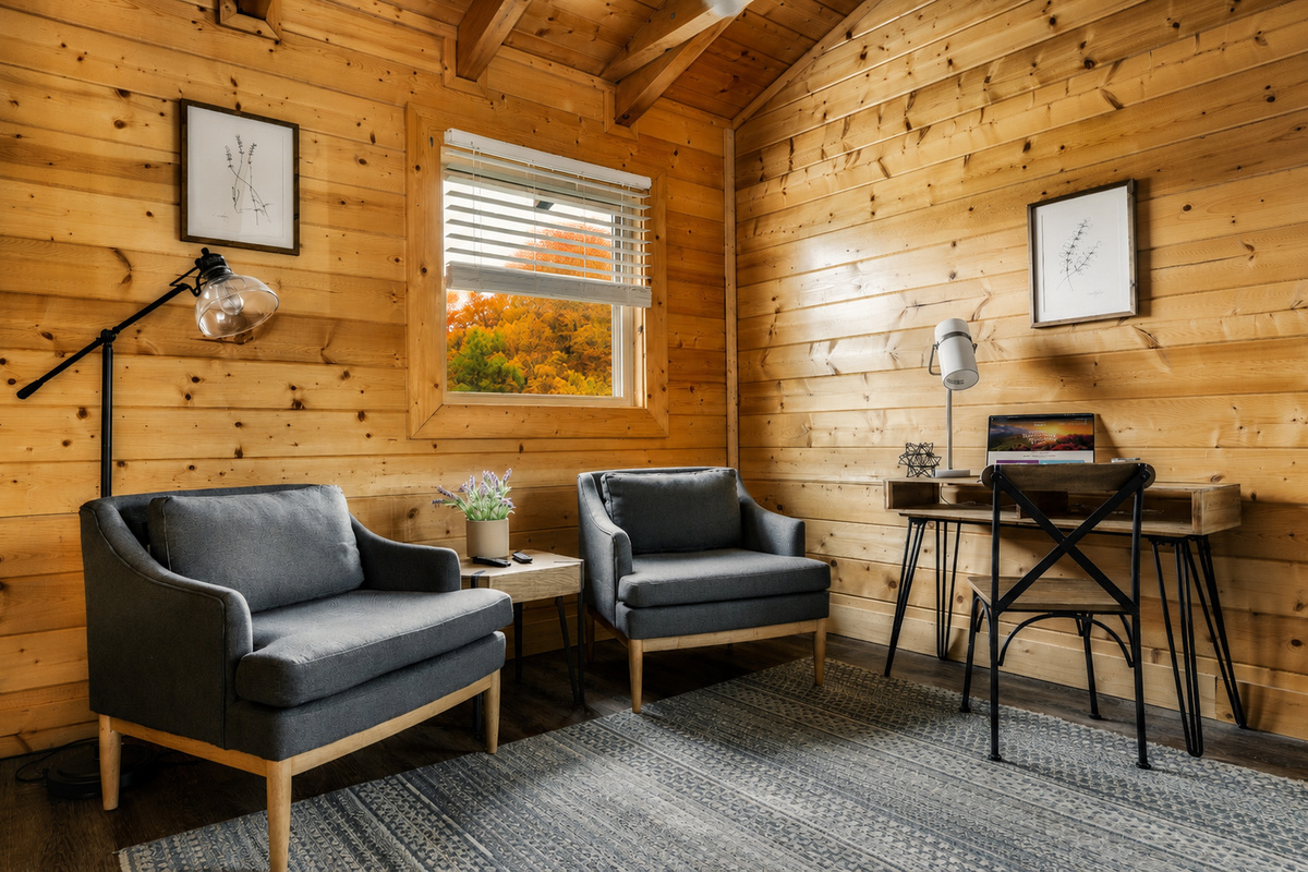 Primary bedroom sitting area includes chairs to lounge, a desk, and television.  Whoever books the cabin gets dibs on this retreat!