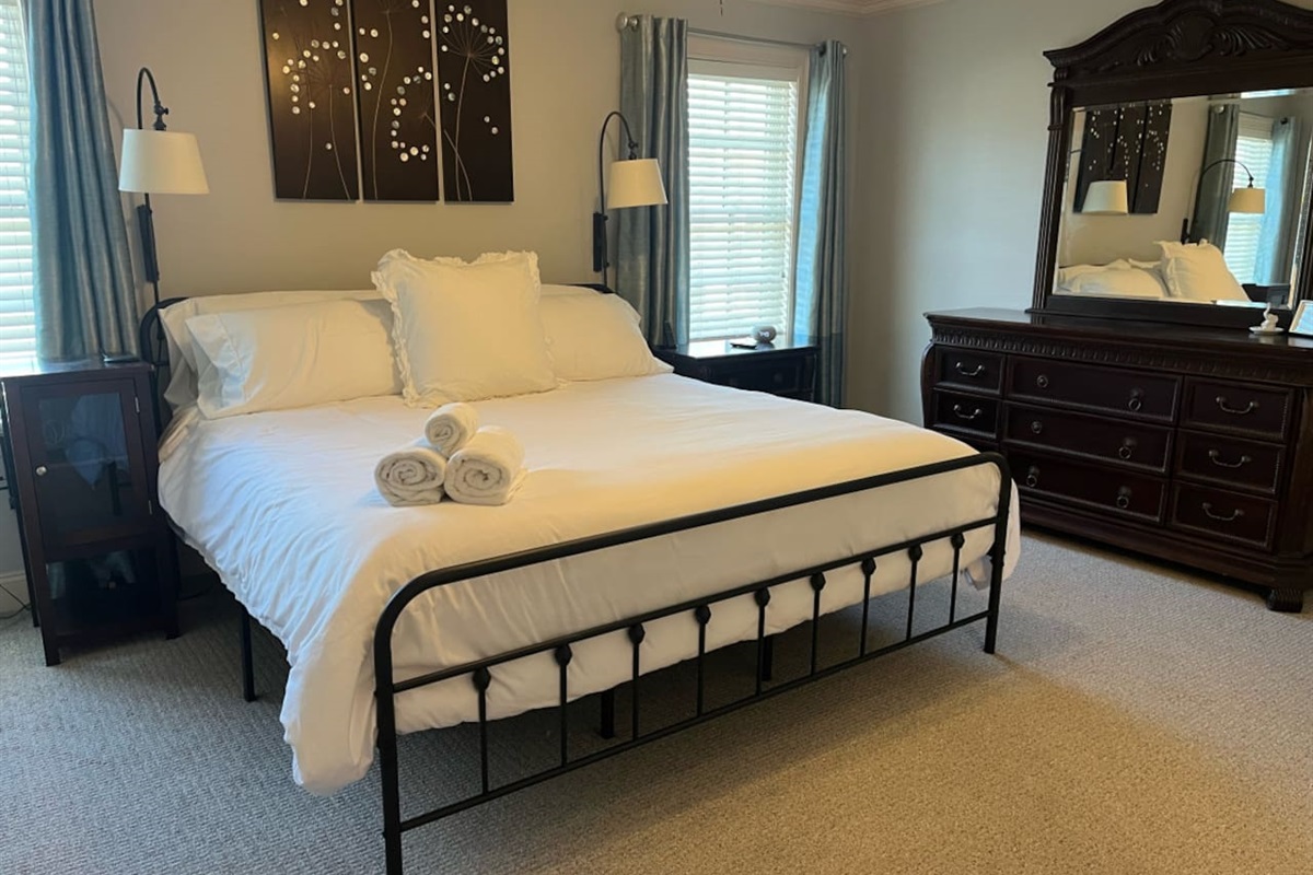 Simple and spacious bedroom with a clean, minimalist design, offering plenty of room to relax and unwind in comfort.