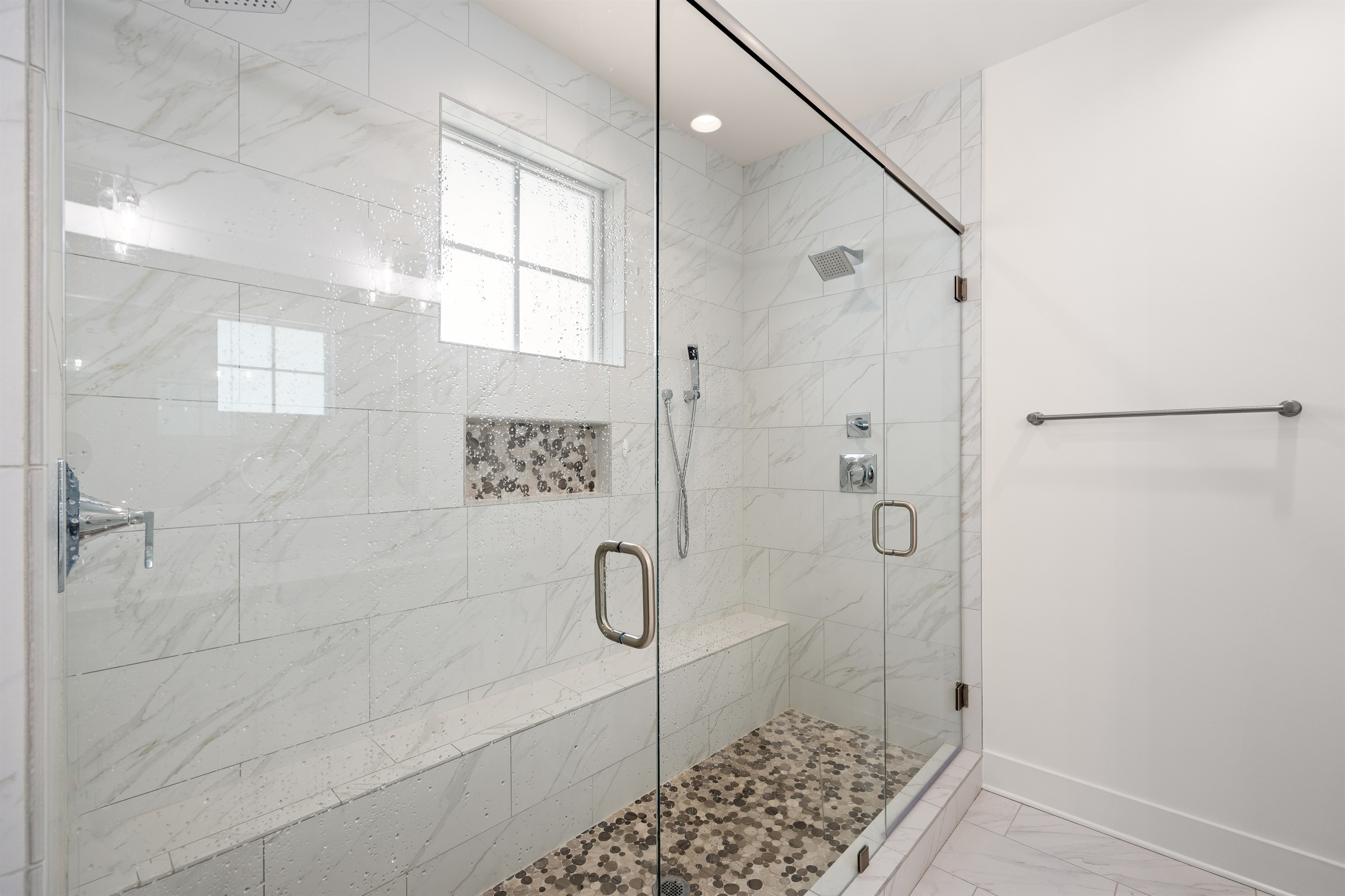 A spacious ensuite bathroom with modern coastal finishes and plenty of room to refresh and recharge.