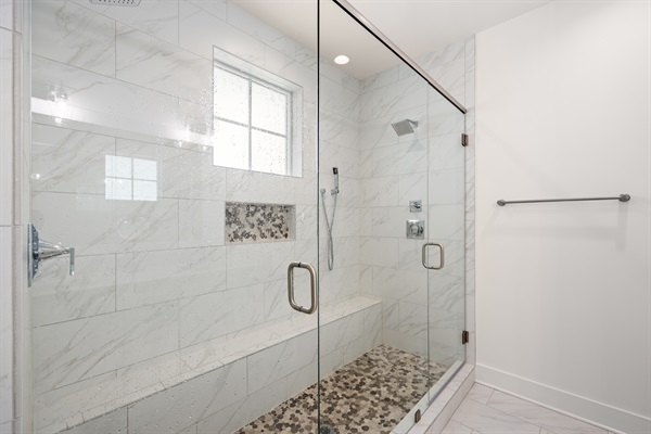 A spacious ensuite bathroom with modern coastal finishes and plenty of room to refresh and recharge.