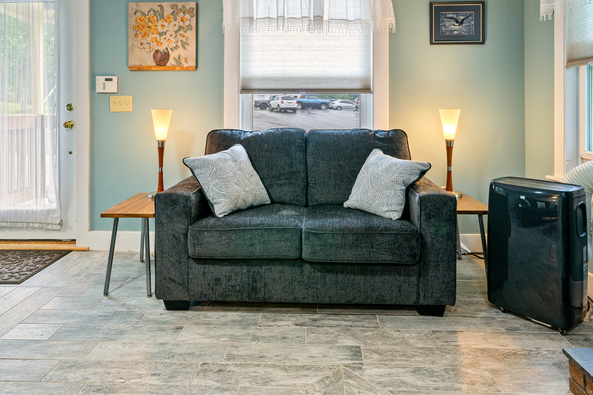 Curl up on the plush loveseat with a good book. With matching end tables and warm accent lamps on both sides, this comfortable living room setup gives your group a perfectly lit, cozy corner to unwind right next to the cooling air conditioner.