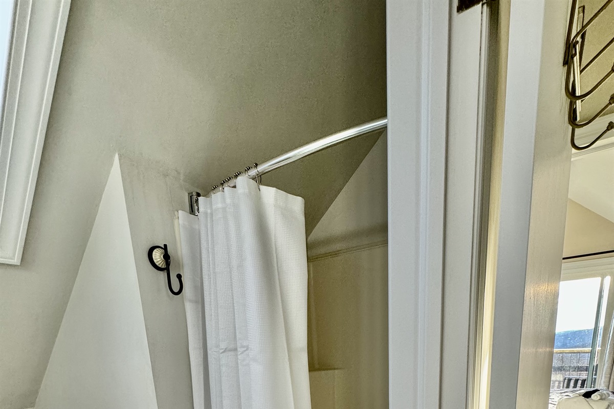 This top floor full bathroom has a shower with a curved shower rod & great storage for guests' toiletry bags! This bathroom recently had a mini-update too.