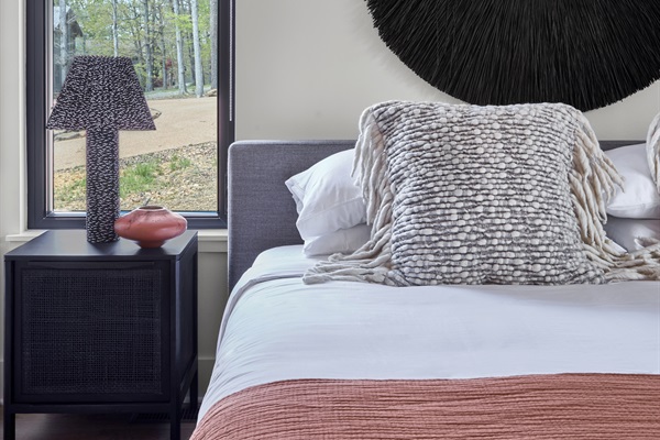 Unwind in your own sanctuary with curated art, luxury bedding, and views of the surrounding trees.