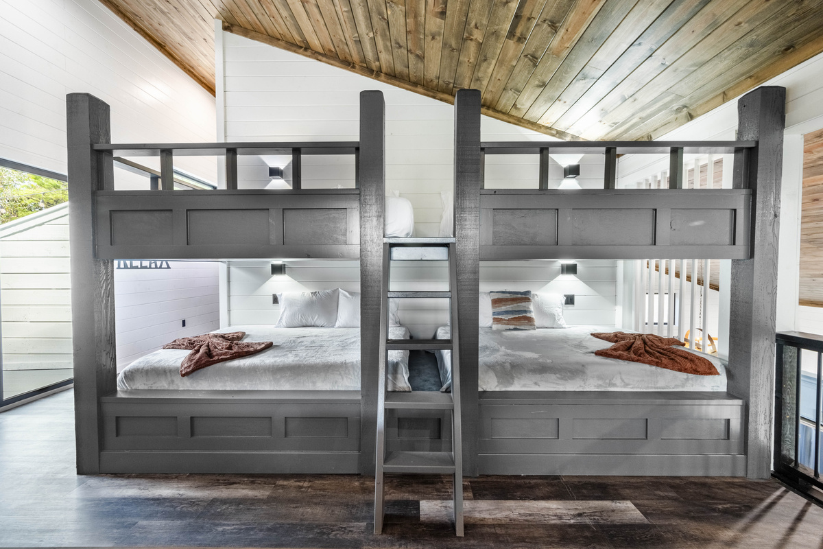 Game room features spacious queen-sized bunk beds designed with comfort in mind offering an unique sleeping arrangement. Enjoy the convenience of having extra sleeping space right near the entertainment