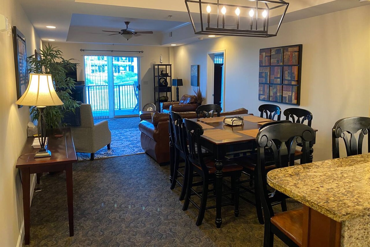 To get to the dining area, simply walk past the kitchen, which seamlessly blends into the living area. The primary bedroom is located on the right-hand side.