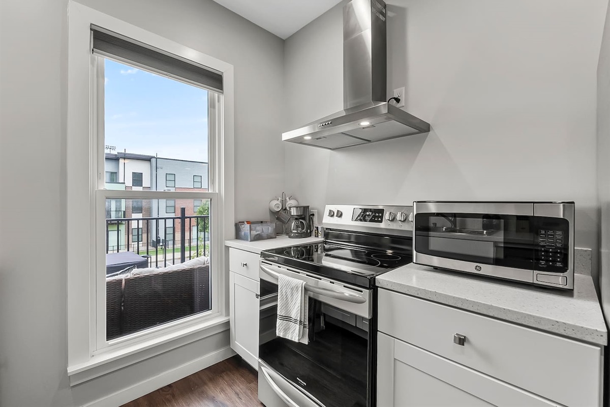 Stainless steel oven, range hood, and microwave ready for home-cooked meals.