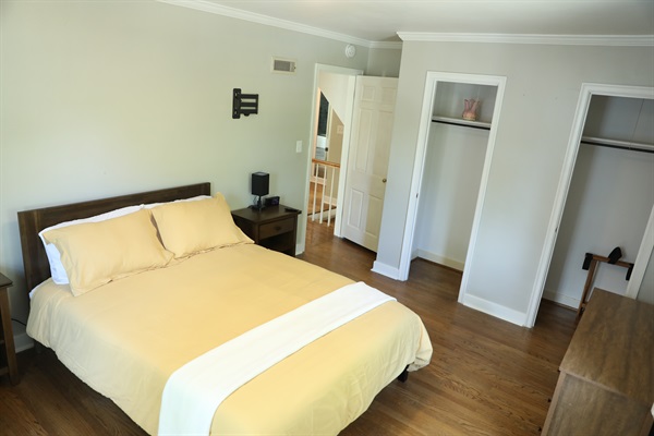 NE Bedroom showing queen size bed, nightstands with touch lamps and alarm clock, Roku TV, and dresser,