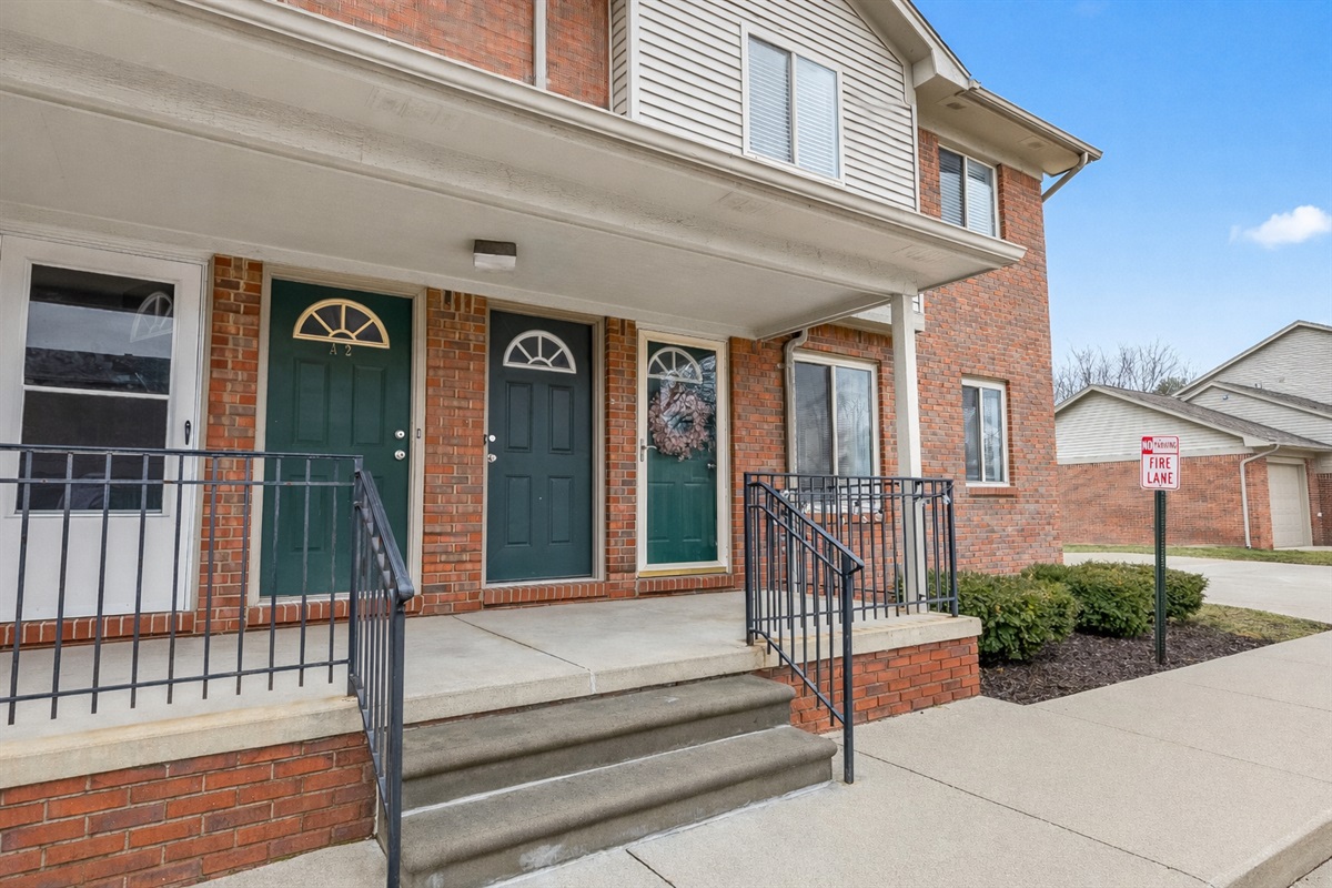 Charming condo entrance with covered porch and easy walk-up access in a quiet, well-kept community.