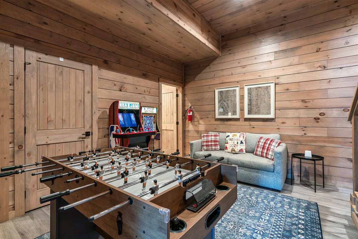 lower level game room with 2 arcades, and a game table with foosball and air hockey. Full-size sleeper size is perfect for kids sleeping near the parents.