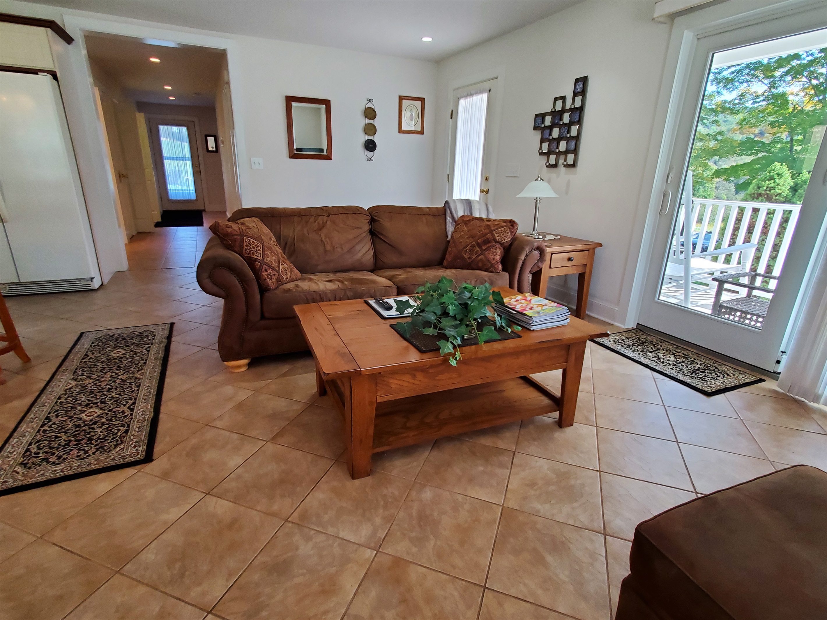 The open living room with sliding glass doors to the large front and side porch.