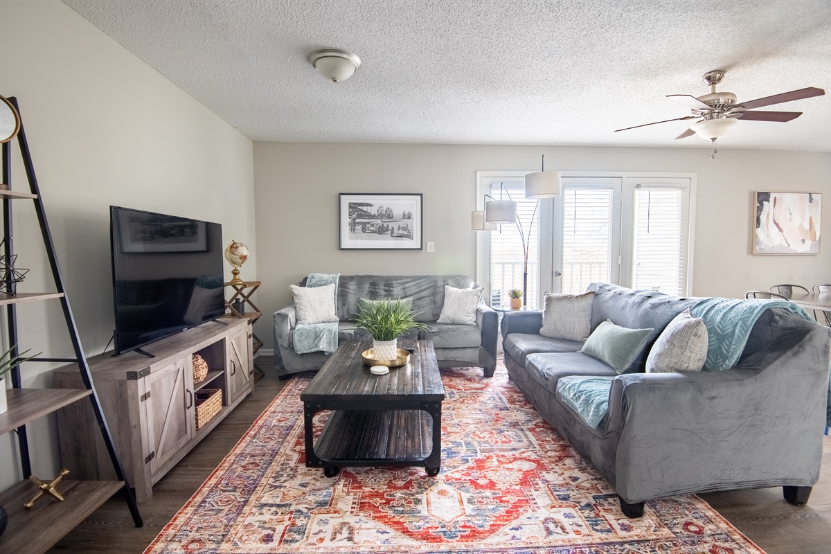 Welcome to Unit A's well-lit living room that has plenty of space for group gatherings, game nights, and settling in for movie marathons on the big smart TV!