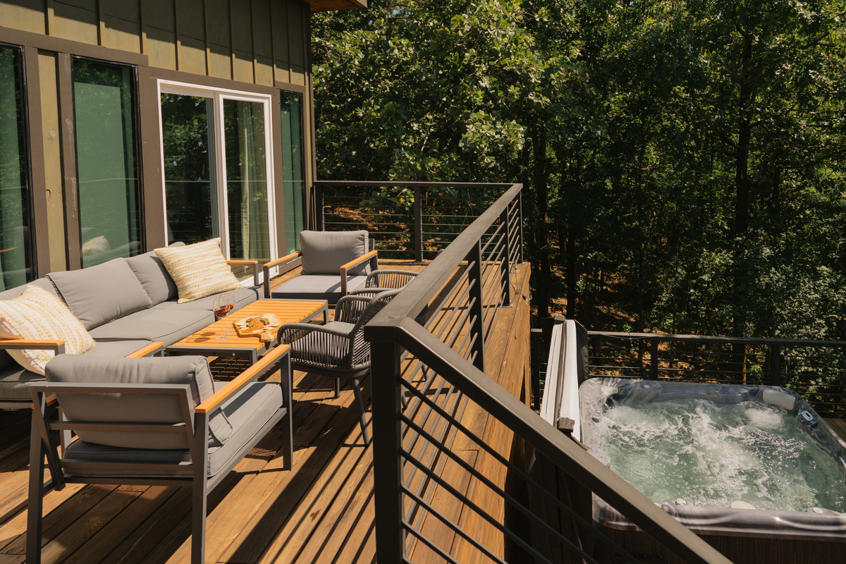 Stunning outdoor deck. Epic views framed by mature hardwood trees. Features a gas-lit firepit and hot tub for cozy vibes.