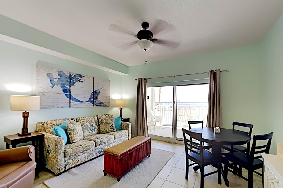 Living room with sleeper sofa, smart TV, recliner, ceiling fan and balcony access