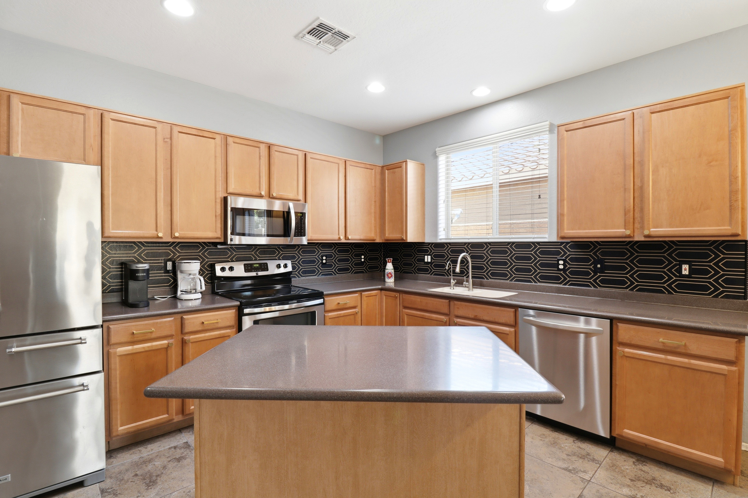 Kitchen with a center island, full appliances, and plenty of space for cooking or serving meals.
