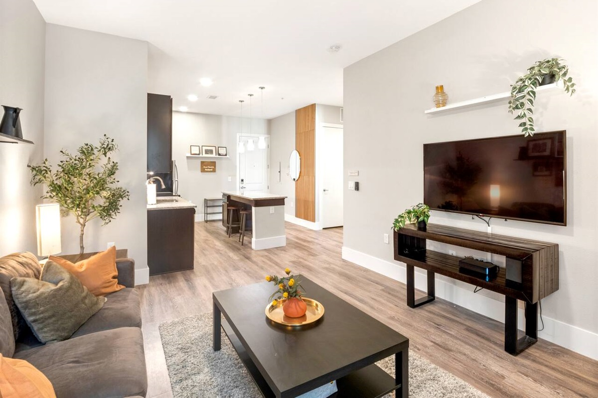 Comfortable living room with high ceilings and open layout. 50 in Smart TV for entertainment