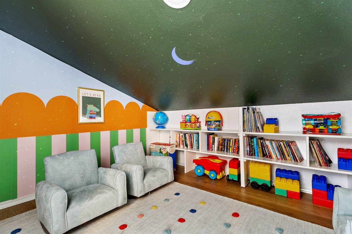 Let’s read, build, and play!   
This dreamy kids’ nook is bursting with books, colorful toys, and cozy seating—all under a magical starry sky ceiling.