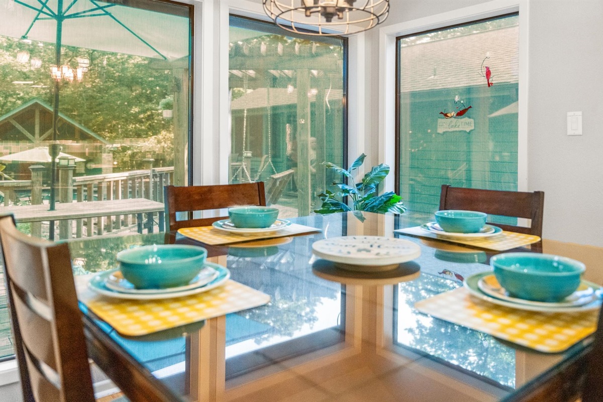 A bright and inviting dining space featuring a counter-height table and chairs, perfectly set for a cozy meal. Enjoy stunning views of the outdoor retreat while gathering with family and friends in this stylish and comfortable setting.