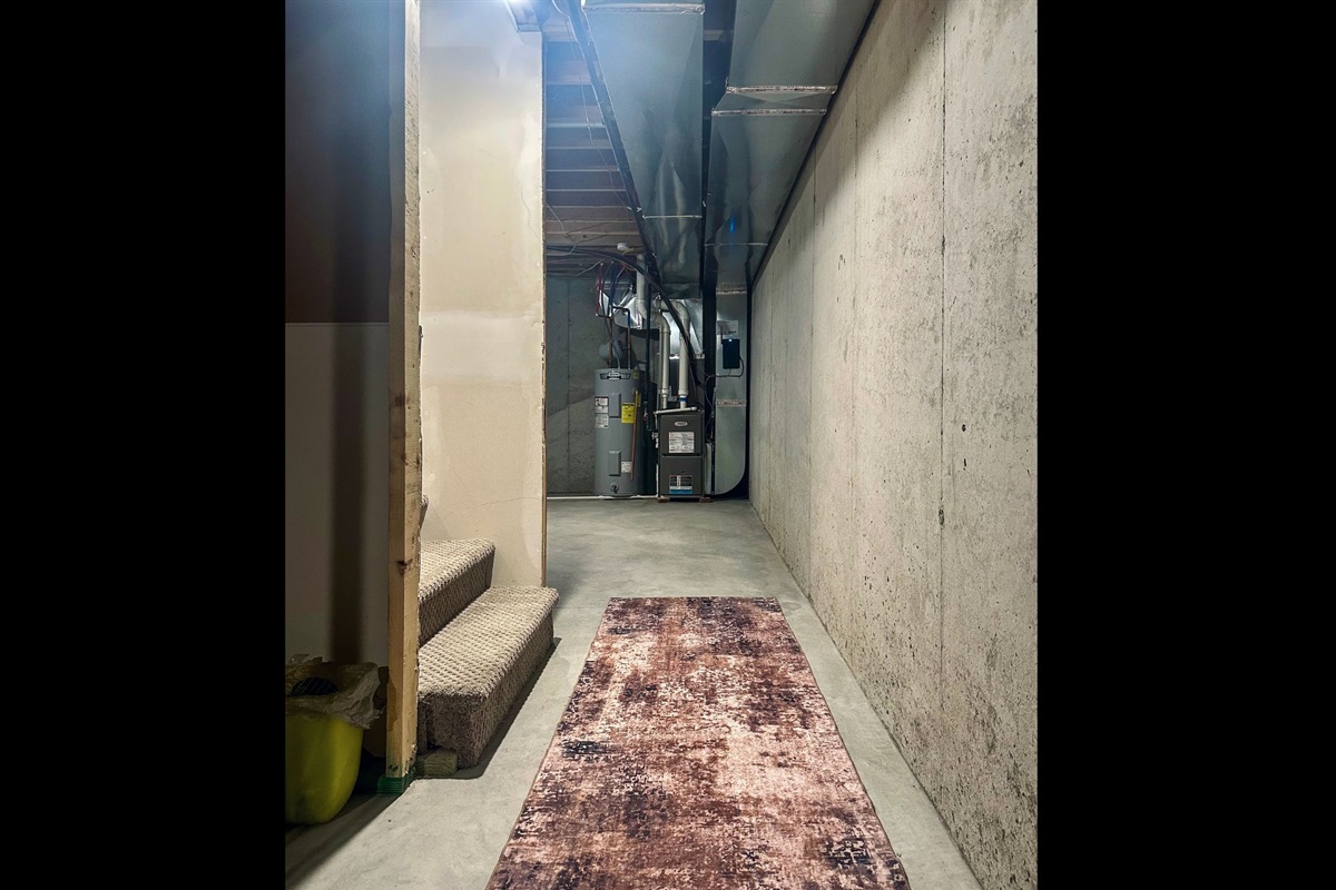 Lower-level landing facing the east side, offering clean, open space with easy access to home systems while maintaining usable room for organized storage.