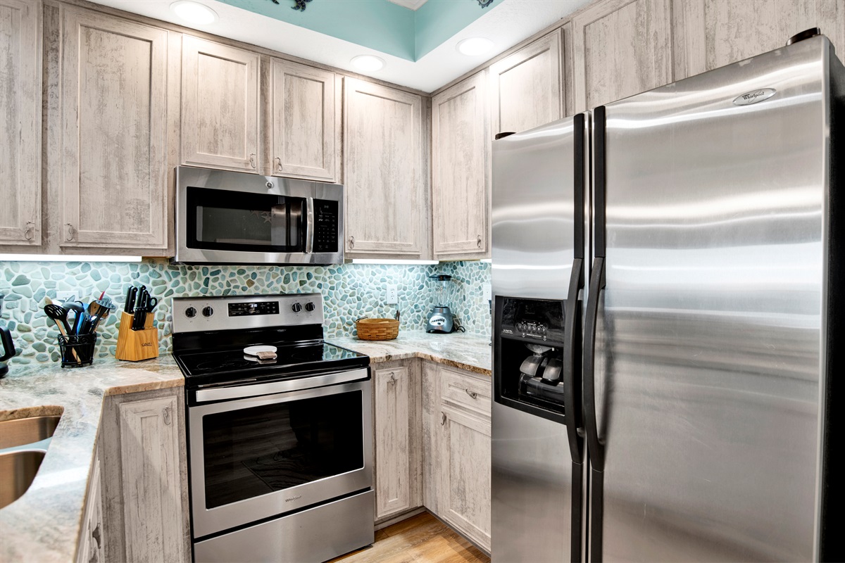 Kitchen with stainless appliances, granite countertops, tiled backsplash and great Gulf view