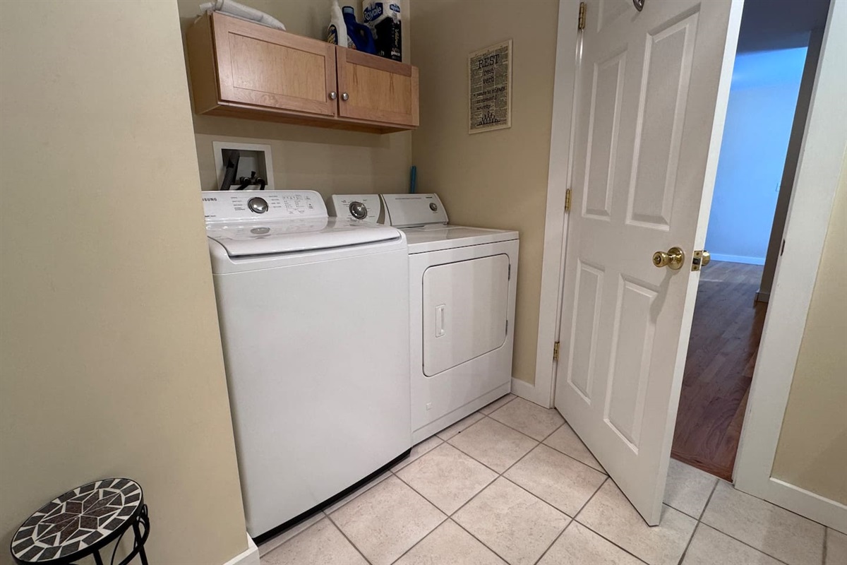 The bathroom has a large jetted tub and shower and a washer and dryer behind the door.