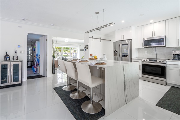 Modern chef kitchen with waterfall island & stainless appliances