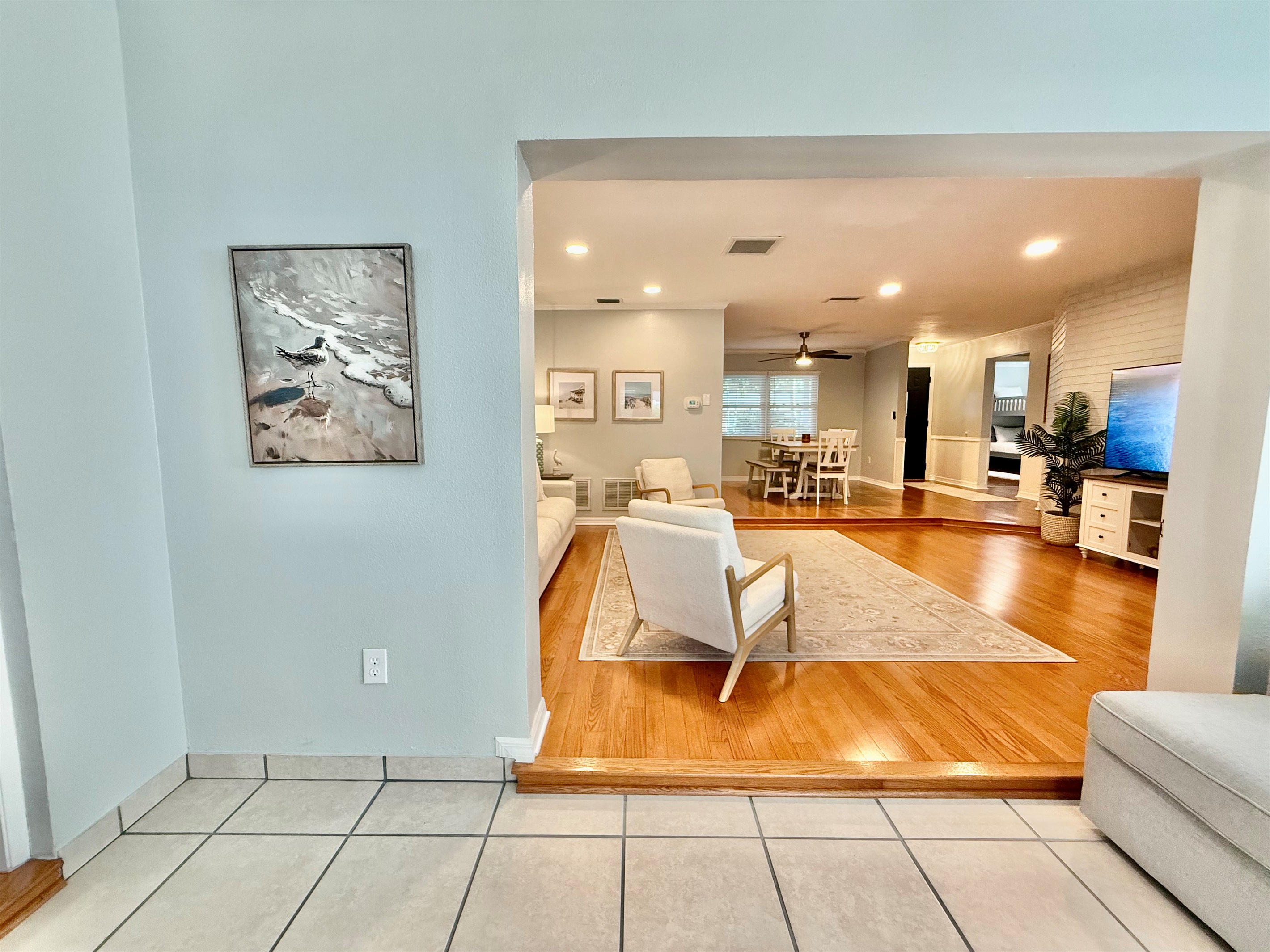Your favorite streaming apps are just a click away on the large smart TV, surrounded by cozy armchairs and a deep, soft sofa.