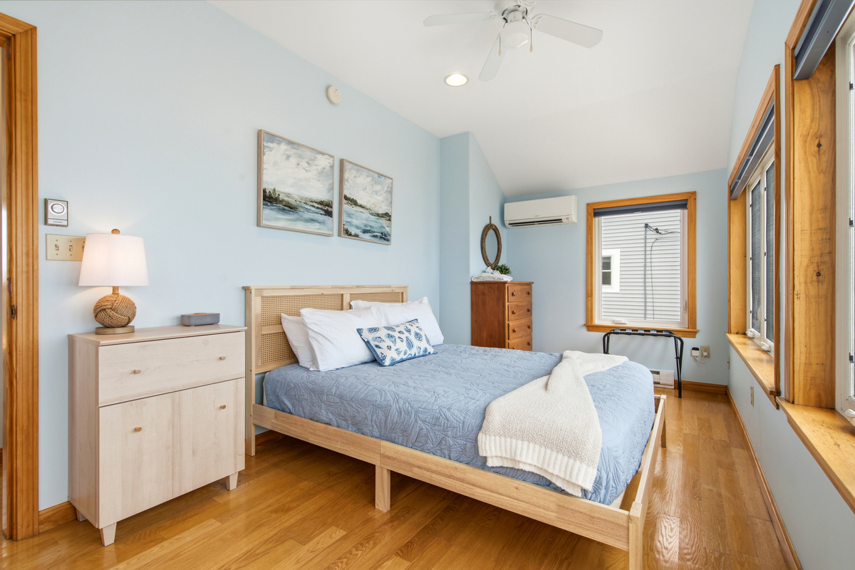 Comfortable queen bedroom featuring coastal décor and panoramic water views.