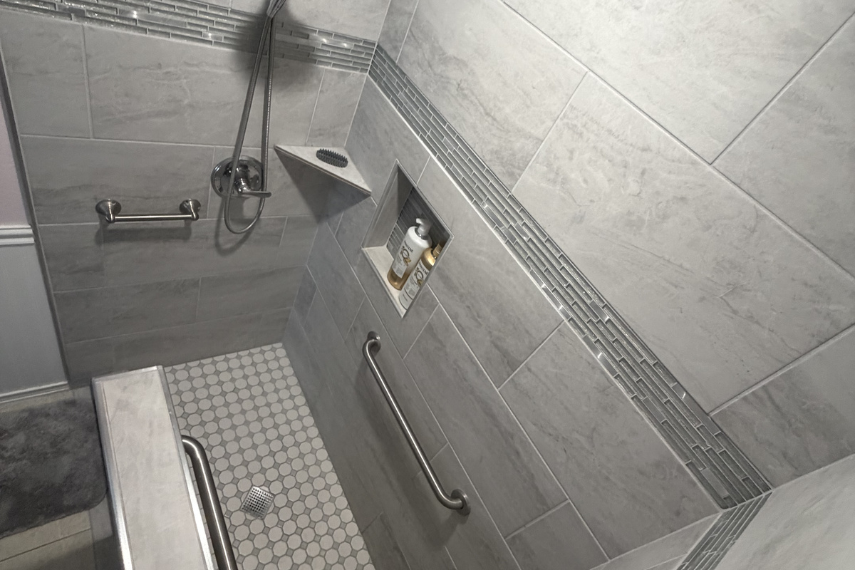 This photo provides a view looking down into the spacious primary bathroom shower, highlighting the layout and accessibility of the space.