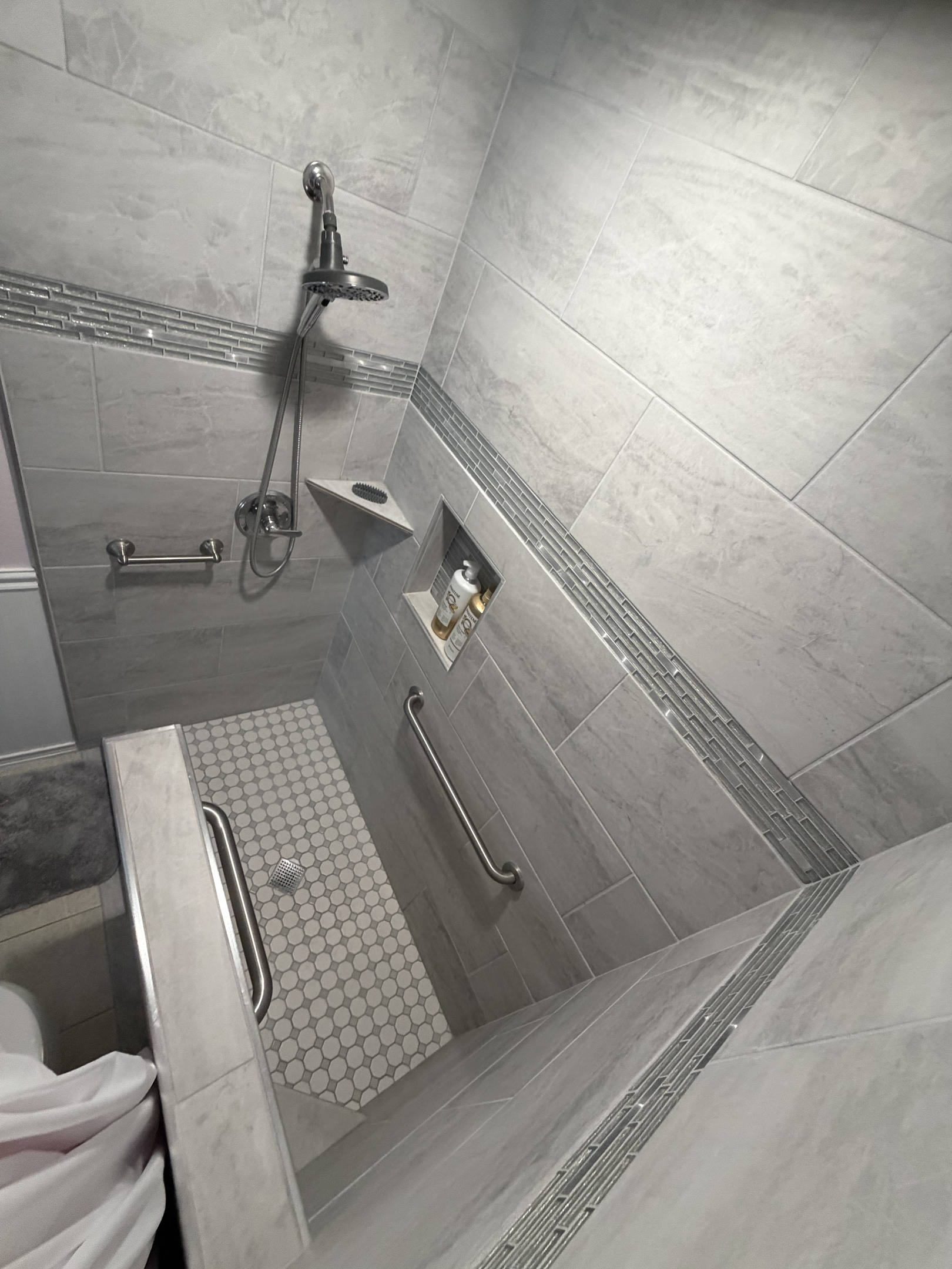 This photo provides a view looking down into the spacious primary bathroom shower, highlighting the layout and accessibility of the space.
