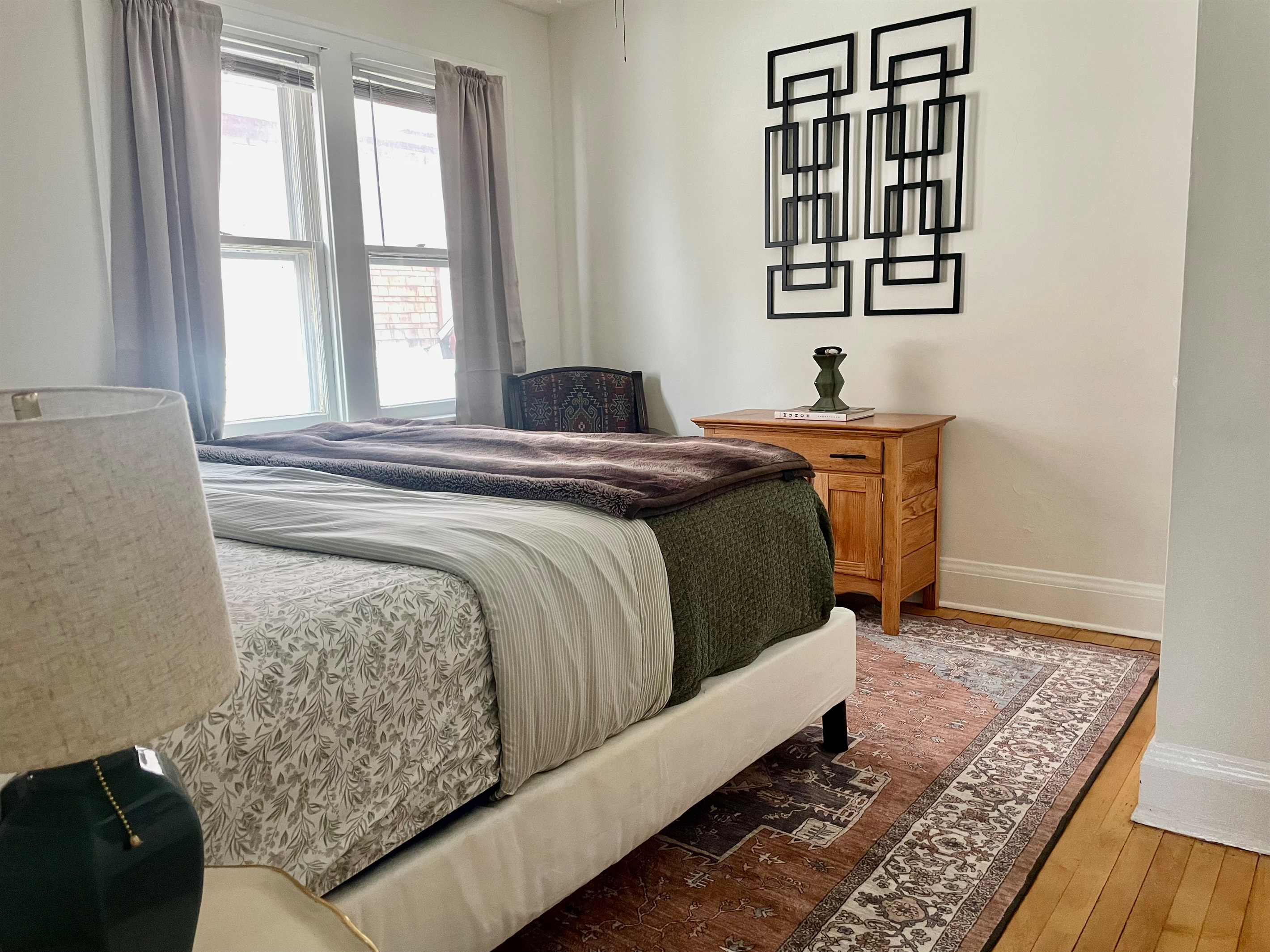 King bed with soft linens in a spacious, comfortable bedroom.