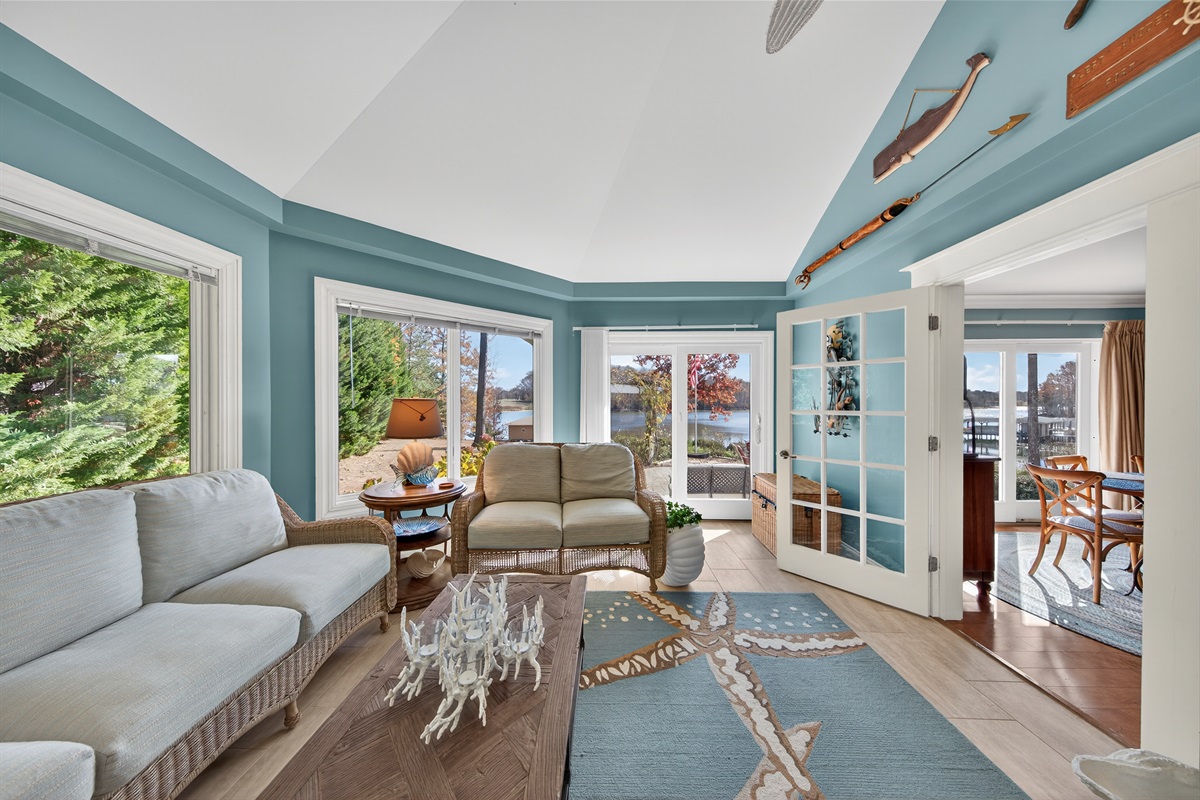 Sunroom with direct views of the lake and easy access to outdoor seating areas.