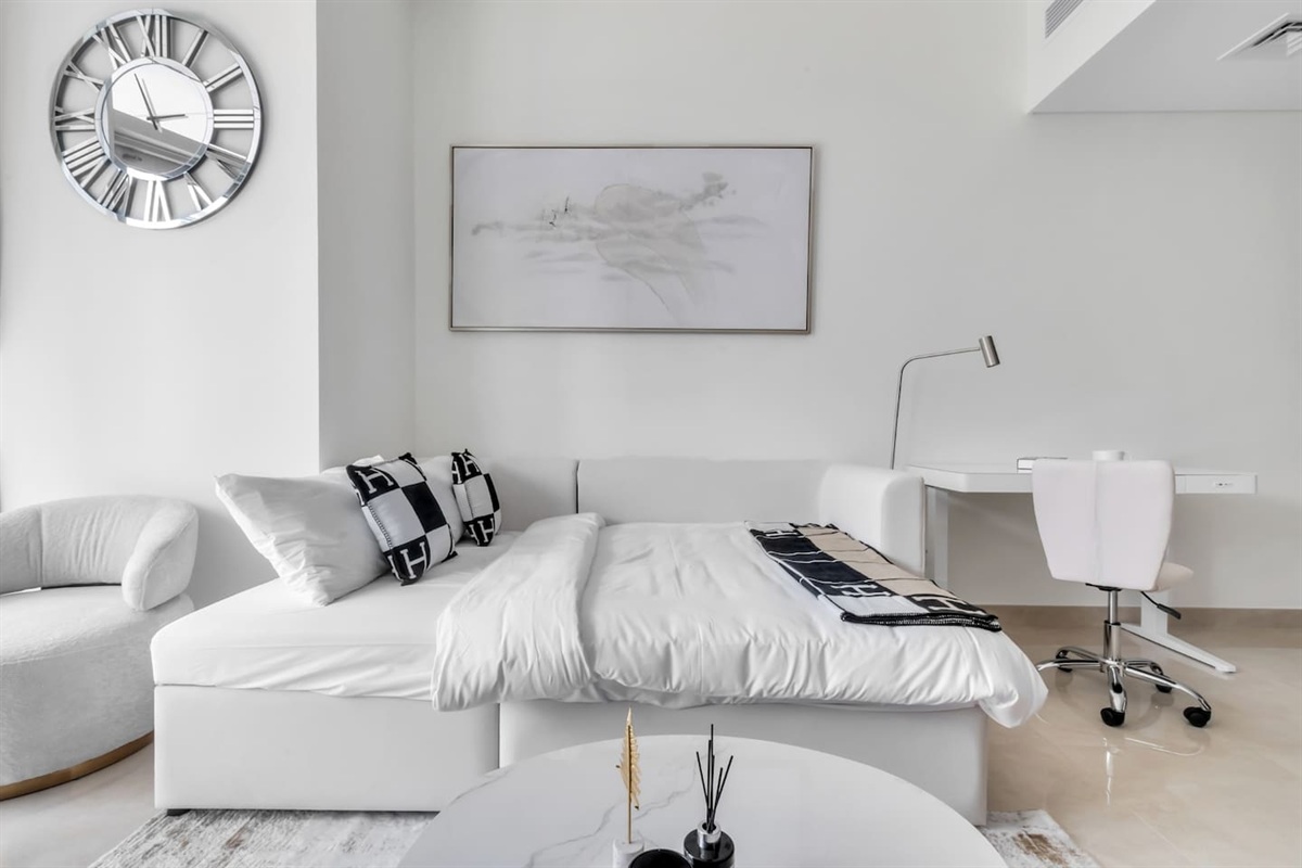 Relax in this bright, modern space with a cozy sofa bed, chic d&eacute;cor, and workspace&mdash;perfect for your stylish Dubai stay