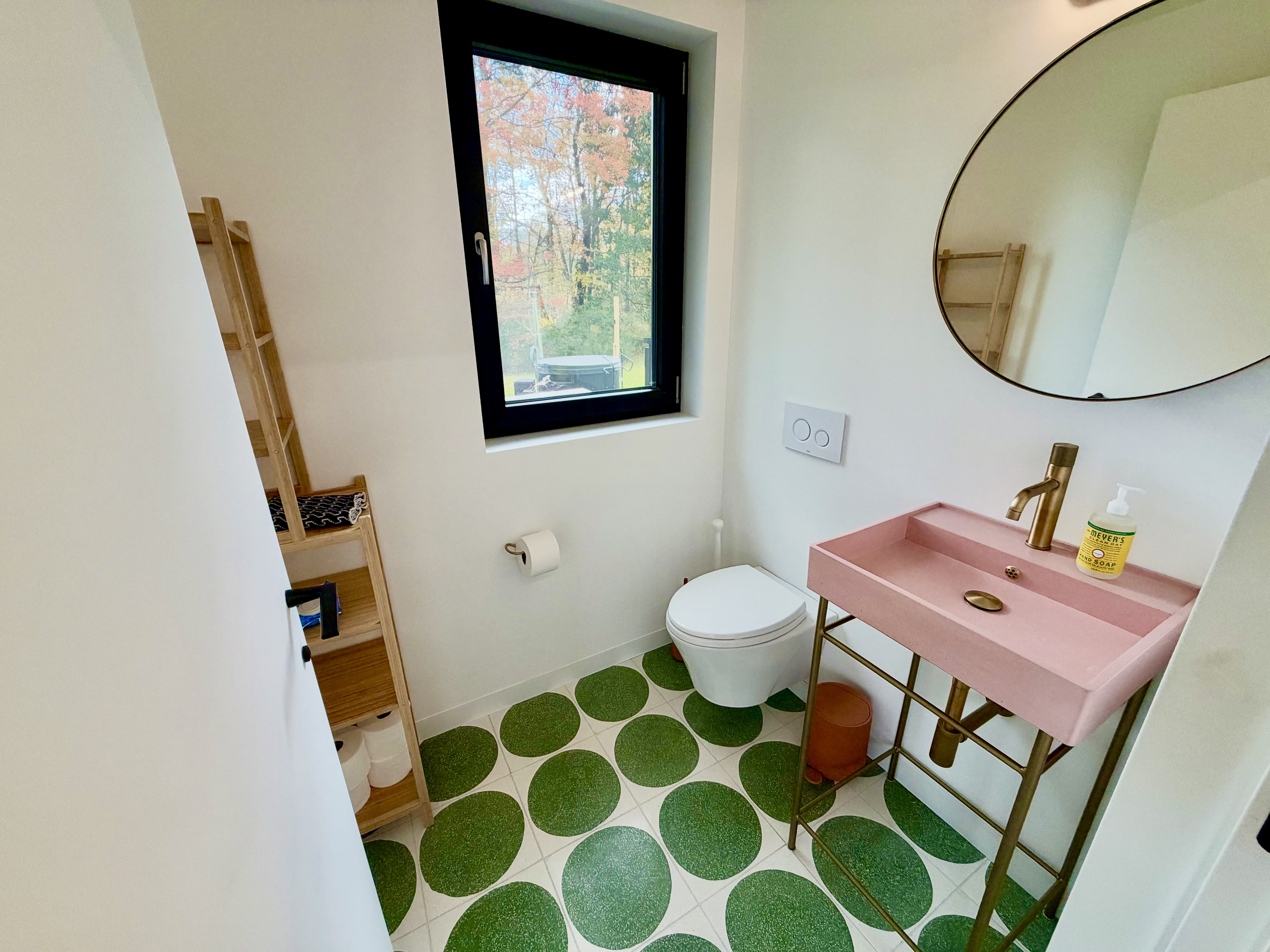 Our entry bath by the front door features a colorful concrete sink and wall mounted toilet.