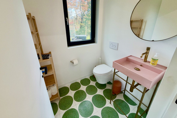Our entry bath by the front door features a colorful concrete sink and wall mounted toilet.