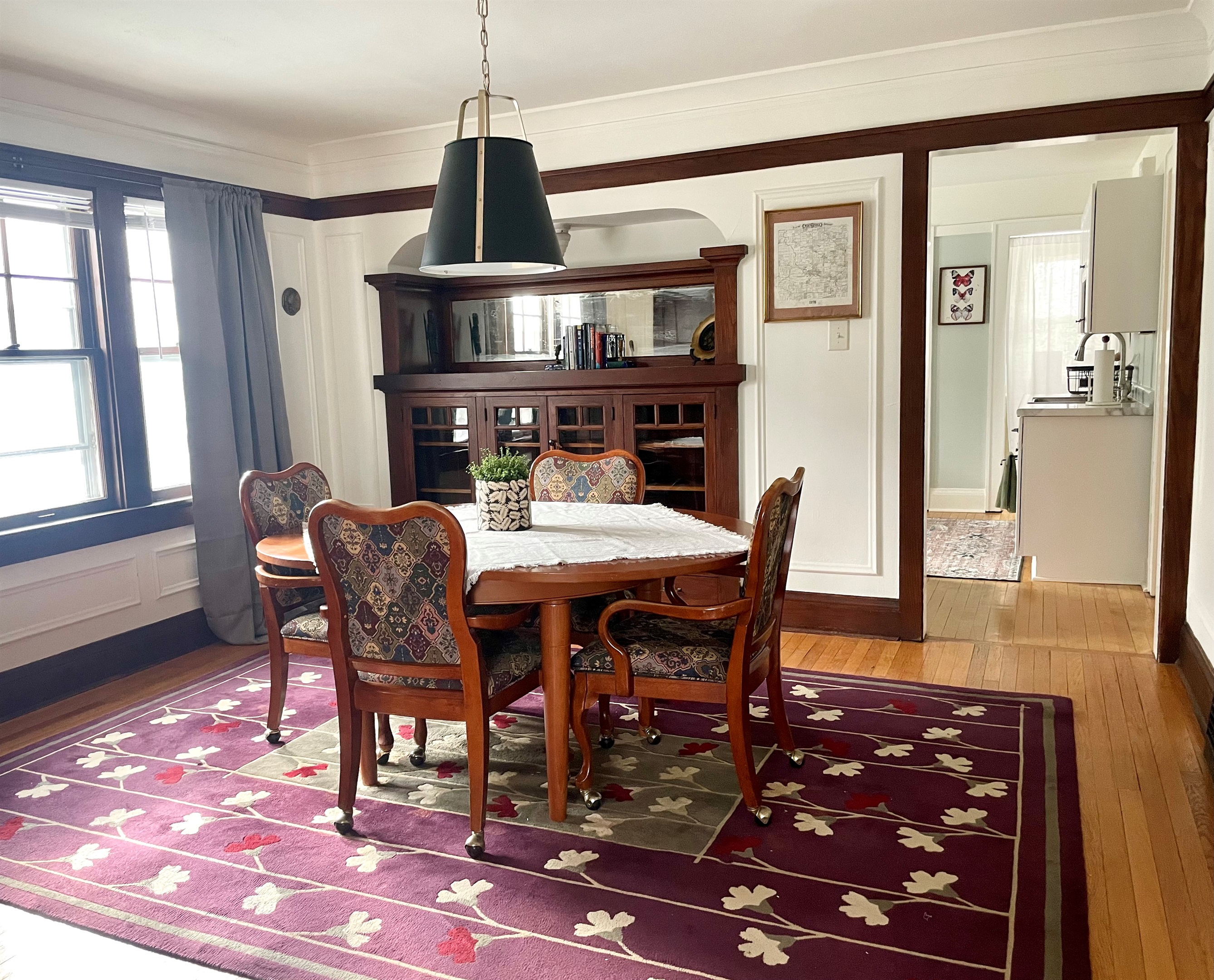 Dining room with table seating for four, filled with natural light and Craftsman charm.
