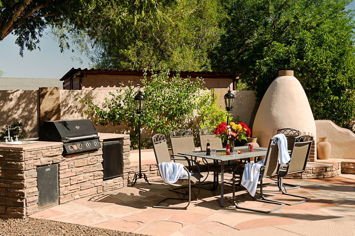 Host unforgettable outdoor meals in this sun-kissed patio space, complete with a built-in grill, elegant dining area, and charming adobe fireplace.