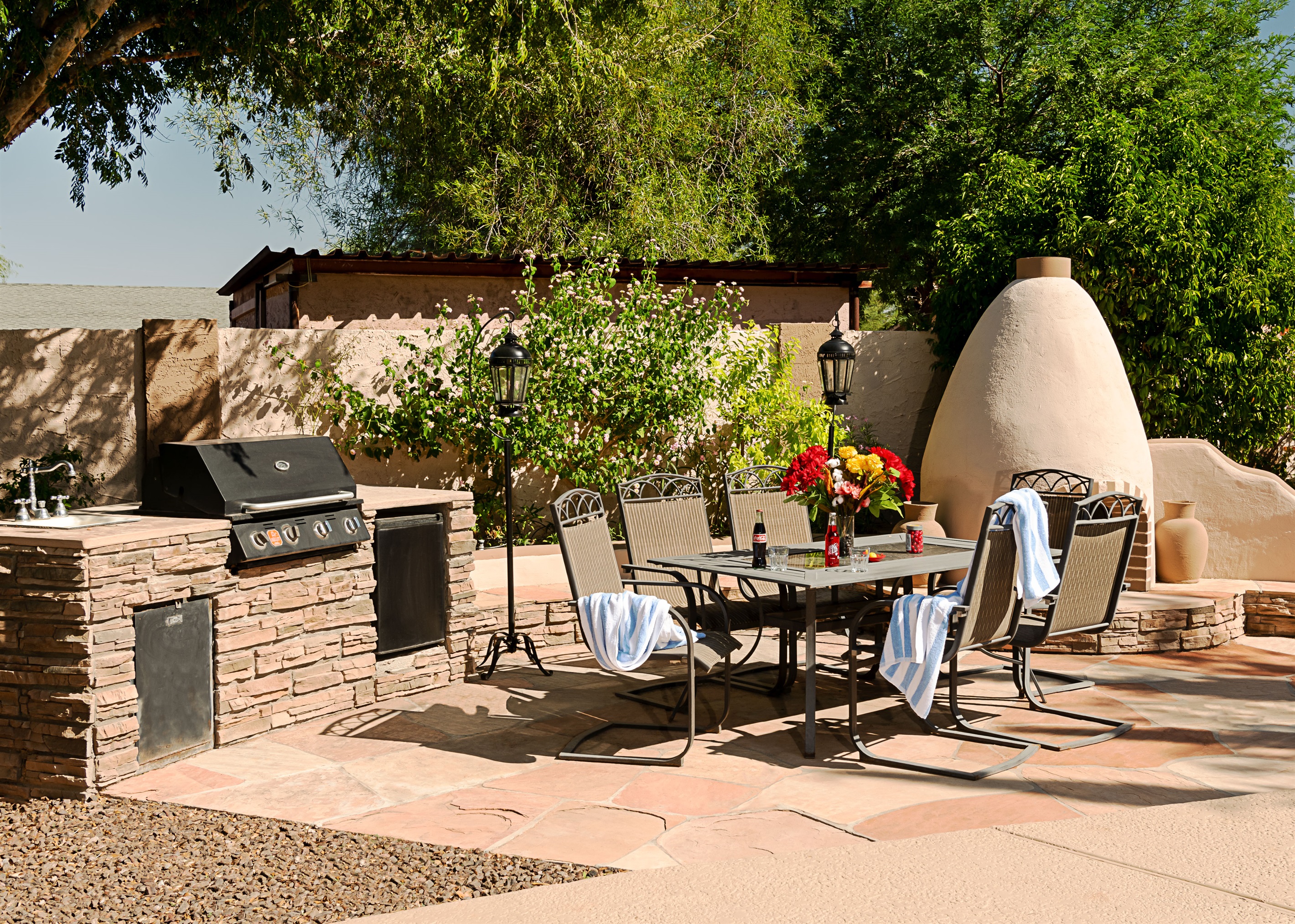 Host unforgettable outdoor meals in this sun-kissed patio space, complete with a built-in grill, elegant dining area, and charming adobe fireplace.