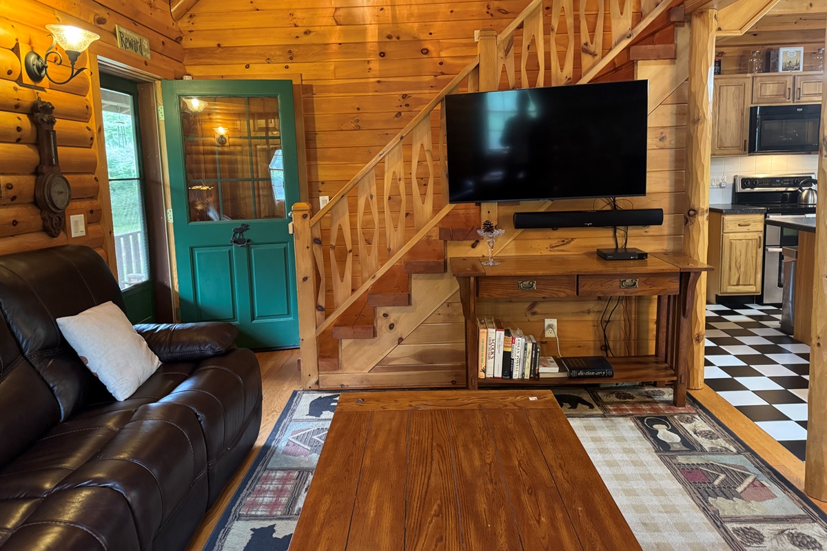 Living area with large SmartTV and stairs to 2nd floor