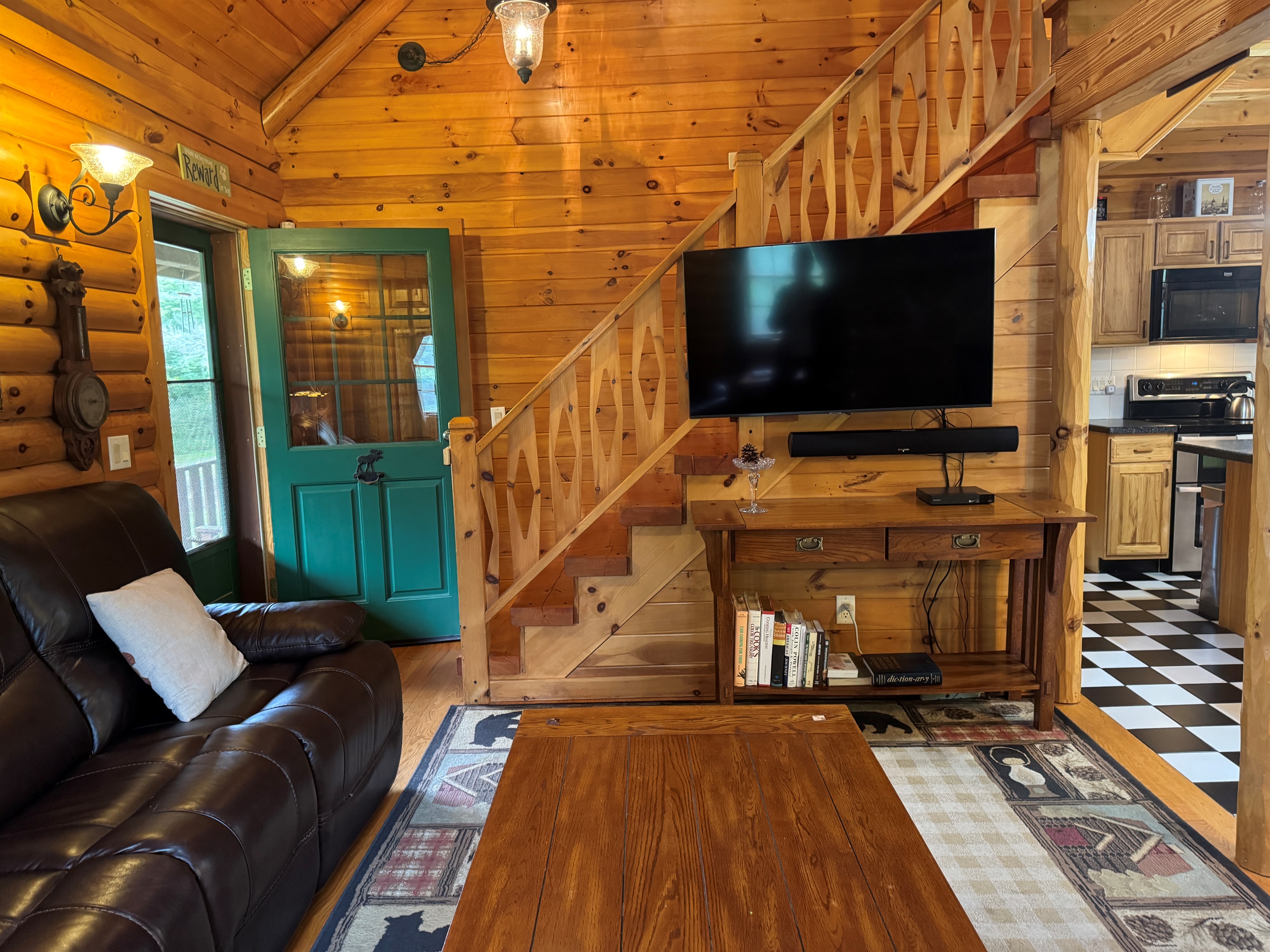 Living area with large SmartTV and stairs to 2nd floor