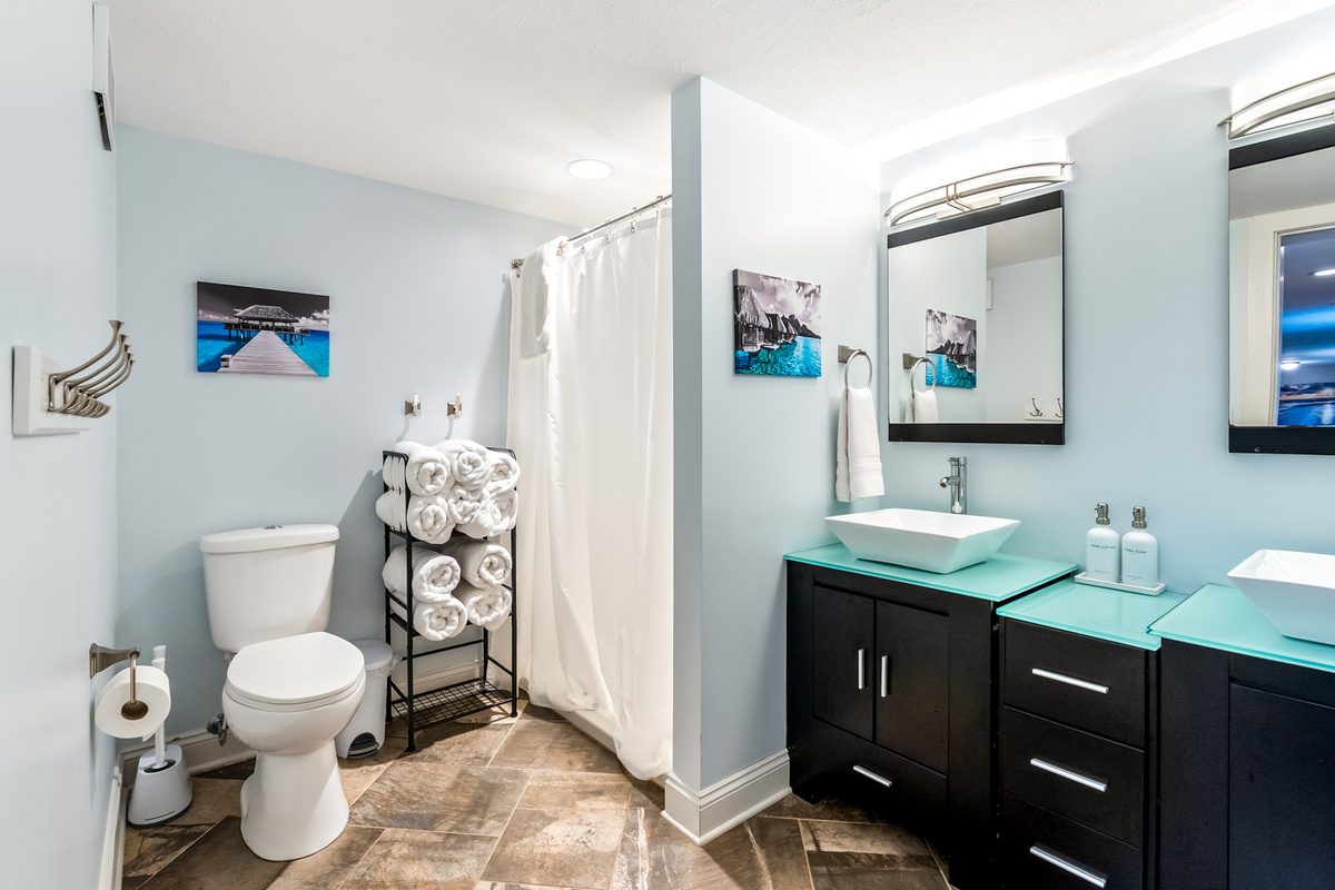 Getting ready for a day at the lake is a breeze. Enjoy the luxury of extra space with our suite's second full bathroom, showcasing sleek vessel sinks, a wide double vanity, and bright, contemporary styling.