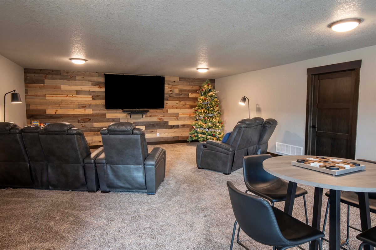 Celebrate the season in this cozy entertainment room, complete with reclining chairs, a big-screen TV, and a glowing Christmas tree—perfect for gathering, watching movies, and opening gifts on Christmas morning.