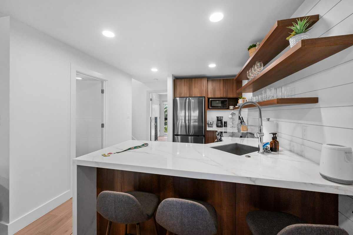 Fully equipped kitchen with ample counter space and seating at the kitchen bar.