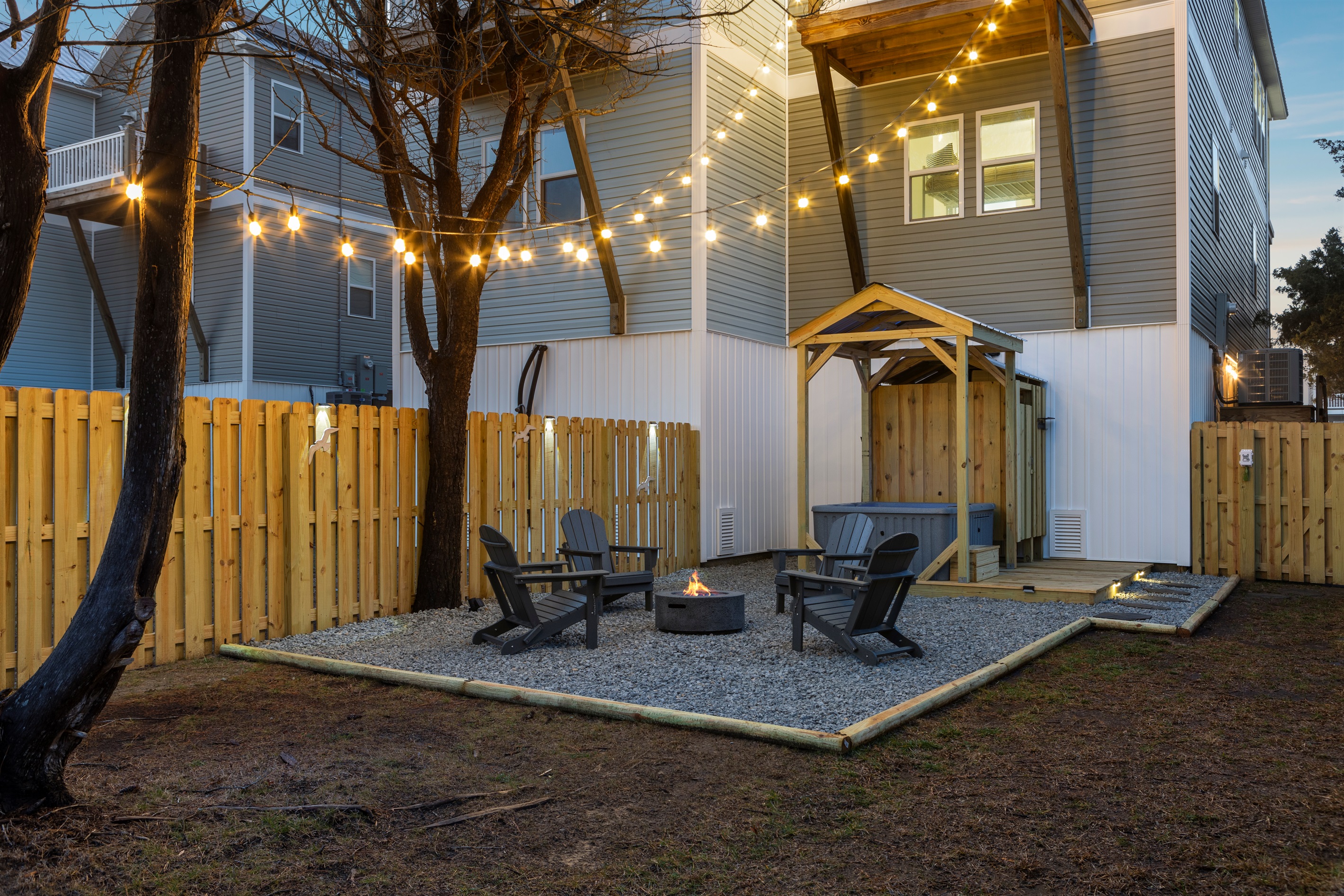 Fully fenced outdoor oasis with hot tub, fire pit, outdoor shower, and propane grill!