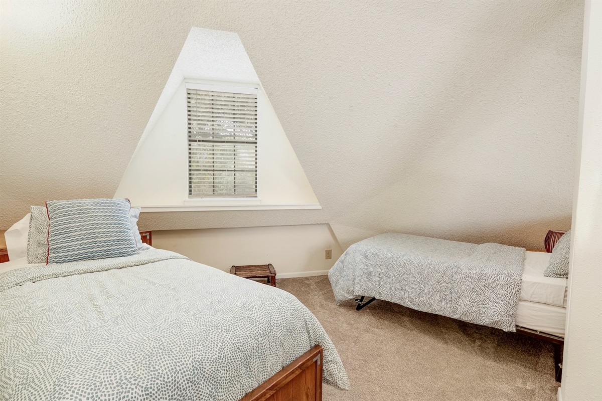 Upstairs loft-style bedroom with two comfy twin beds