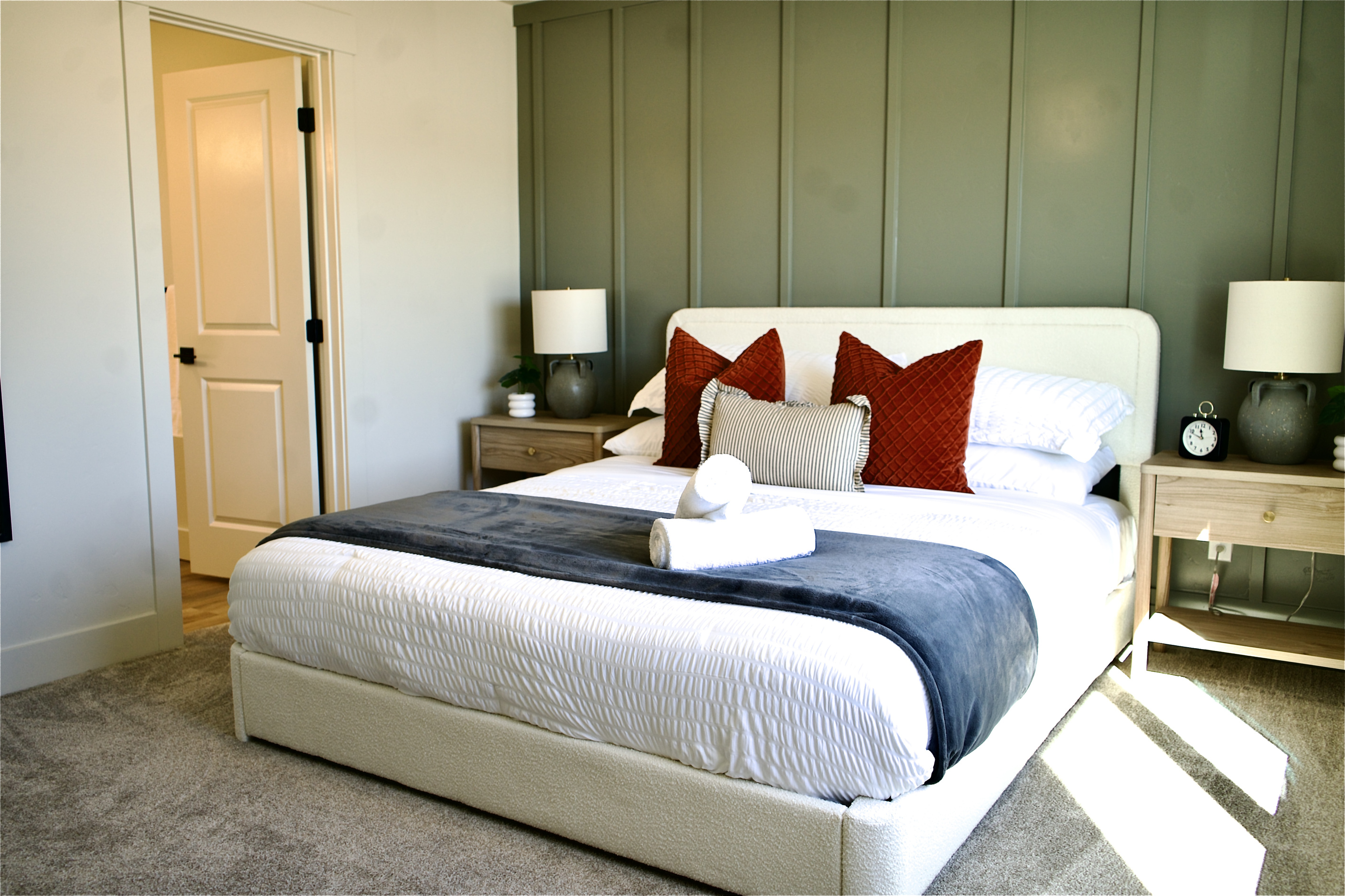 The primary suite is located upstairs and features a beautiful sage green accent wall. The en-suite bathroom includes a walk-in shower, dual vanities, a private water closet, and an oversized walk-in closet. It includes a Smart TV for comfort. 