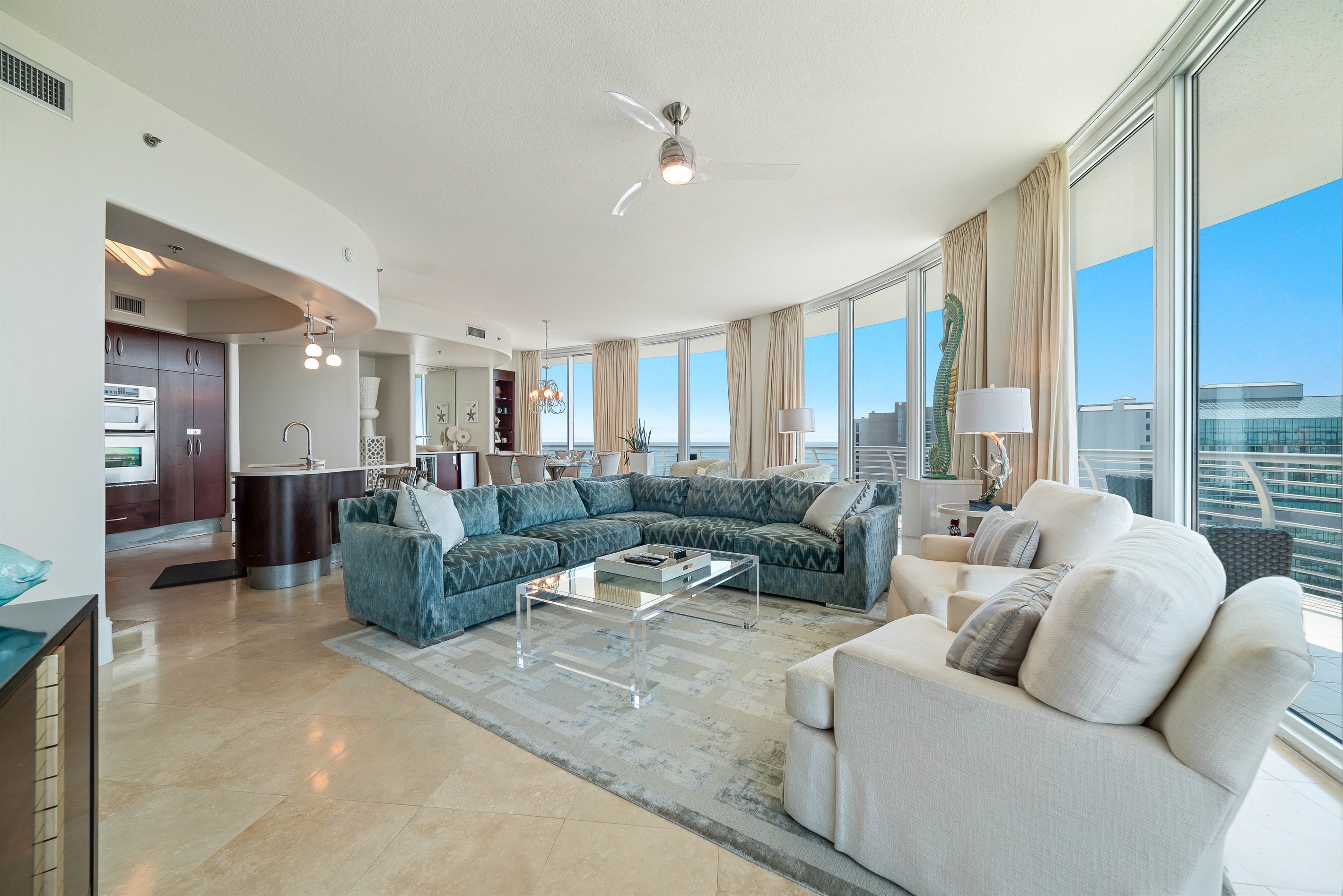 Experience the epitome of coastal living in this beautifully designed living room. Featuring plush furnishings, a serene color palette, and expansive views, this space offers a tranquil retreat for residents and guests alike.