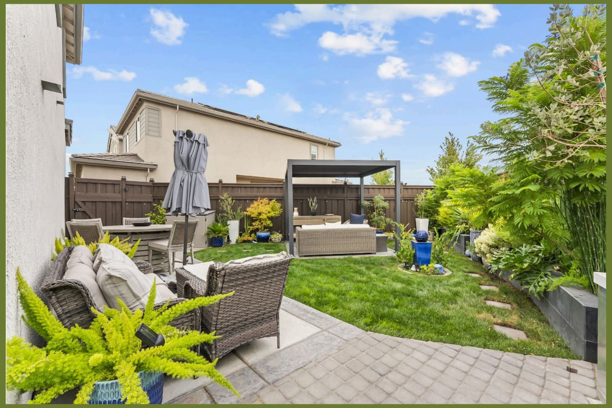 Backyard garden with lounge seating, covered pergola, patio dining, and a green lawn for relaxing outdoors.