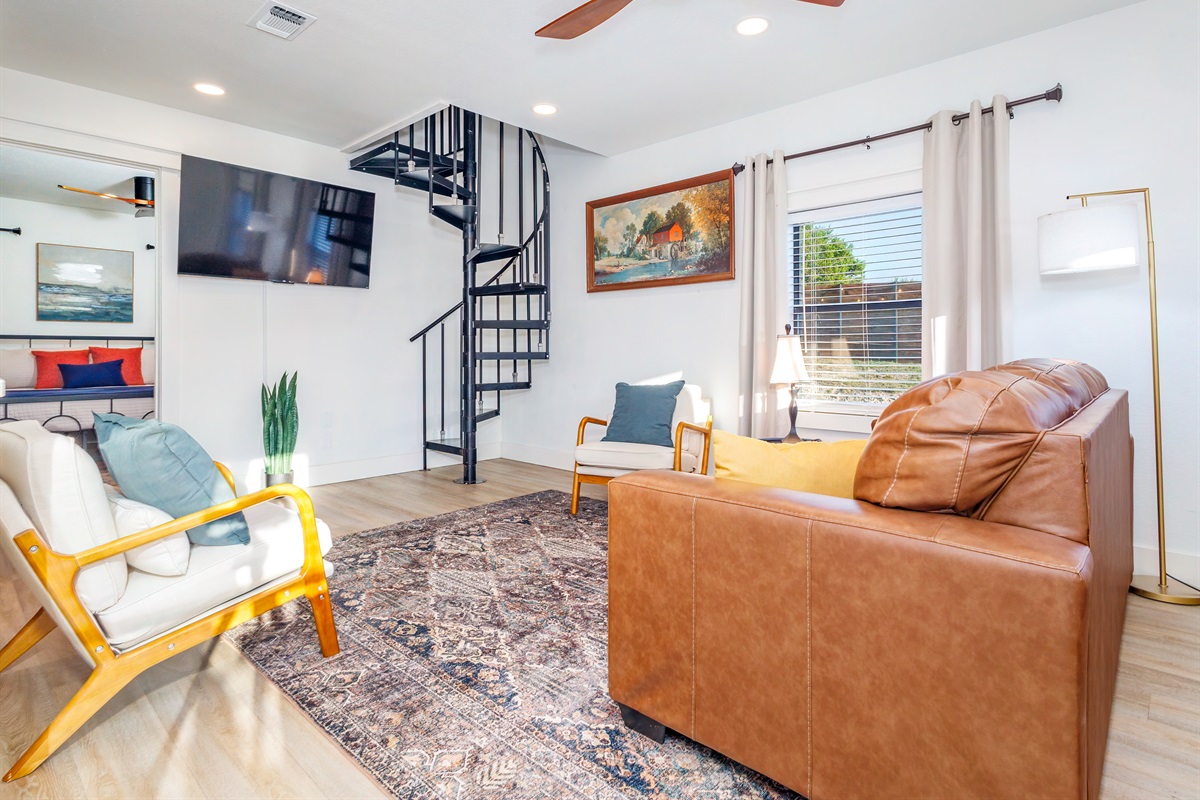Cozy up and relax in the inviting living space, with a spiral staircase that leads to the second loft bedroom.