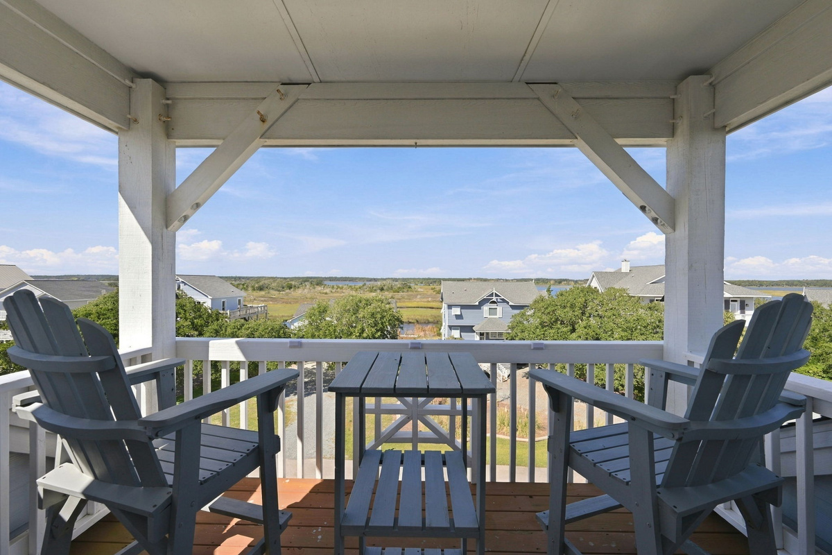 Covered balcony with Adirondack chairs, perfect for enjoying refreshing ocean breezes and elevated coastal views